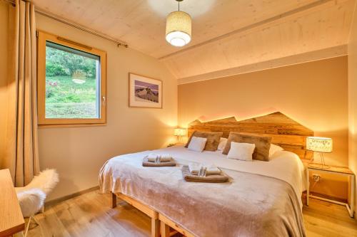a bedroom with a large bed and a window at L'Ecrin de Venosc piscine privée in Les Deux Alpes