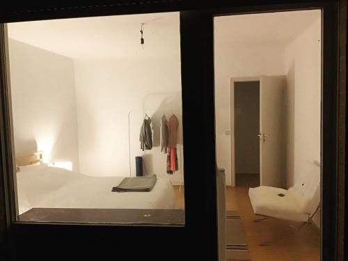 a bedroom with a white bed and a chair at Haus am Reithagen in Hofgeismar