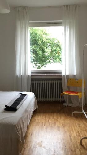 a bedroom with a bed and a window and a chair at Haus am Reithagen in Hofgeismar