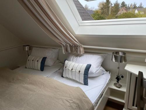 a small room with two beds and a window at Meerchenhaus in Wenningstedt