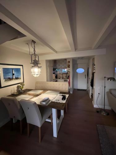 a dining table and chairs in a living room at Meerchenhaus in Wenningstedt