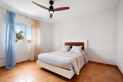 a bedroom with a bed with a ceiling fan at Mayantigo in Juan Gopar