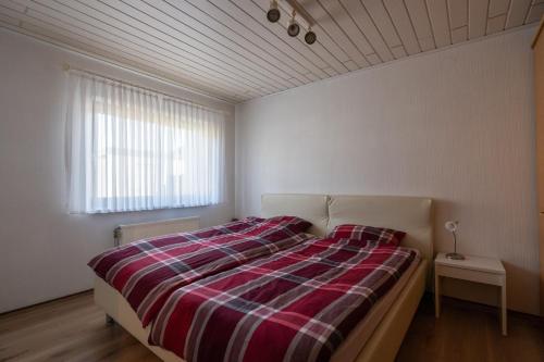 a bedroom with a bed with a plaid blanket at Juttis Bude in Löhnberg