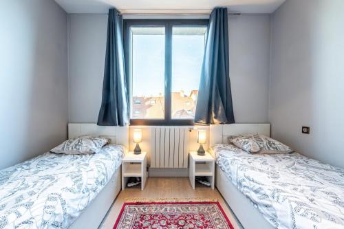 two beds in a room with a window at Annecy - Le 10 in Annecy