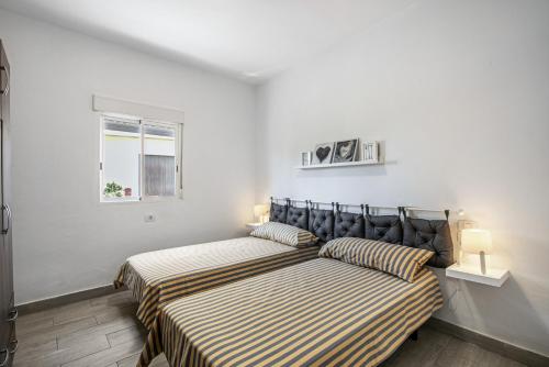a bedroom with two beds and a window at Oramas Secret Cellar – Casa Rural in Arico
