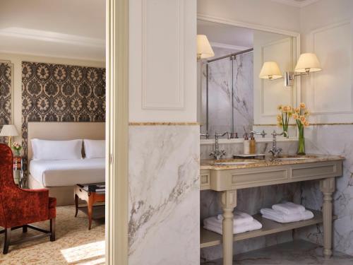 a bathroom with a bed and a sink and a mirror at Hotel El Palace Barcelona in Barcelona