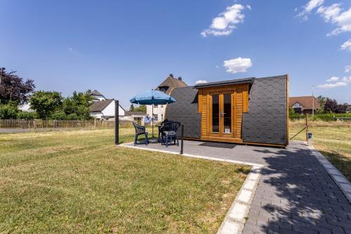 a tiny house with a porch and a patio at Campingpod Auf Der Alpakawiese in Arnsberg