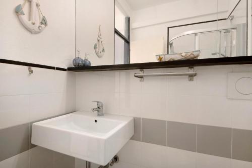 a white bathroom with a sink and a mirror at Nonna Adele in Sestri Levante