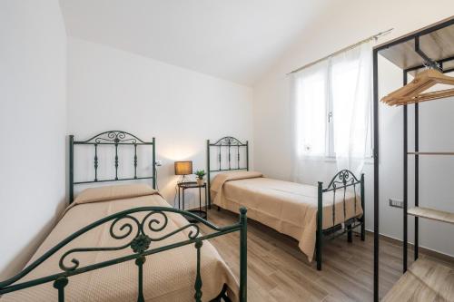 a bedroom with two beds and a window at Casa Vacanze Alba Mar in SantʼAntìoco