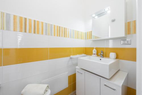 a bathroom with a white sink and a mirror at Casa Vacanze Alba Mar in SantʼAntìoco