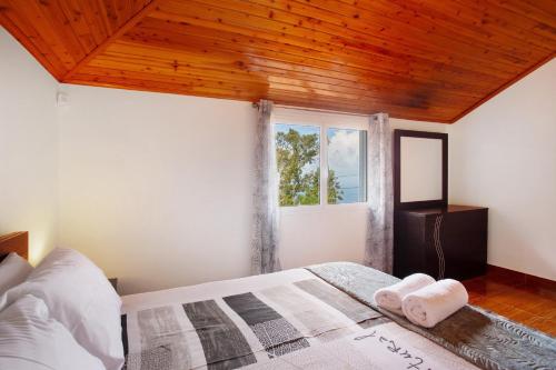 a bedroom with a bed with a wooden ceiling at Casa Estrela Do Norte in Ponta Delgada