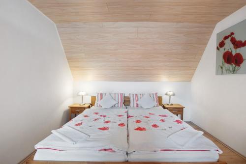 a bedroom with a bed with red flowers on it at Ferienwohnung am Blumengässle in Müllheim