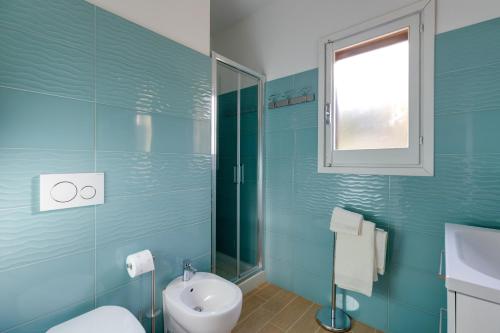 a blue bathroom with a toilet and a sink at Casa Donatella Torre dei Corsari in Torre Dei Corsari