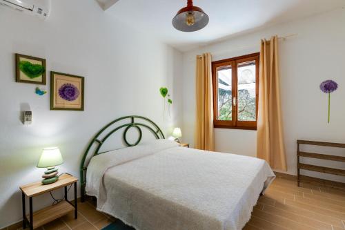 a bedroom with a white bed and a window at Casa Donatella Torre dei Corsari in Torre Dei Corsari