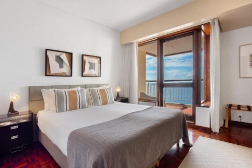 a bedroom with a large bed and a large window at Vista Formosa in Funchal