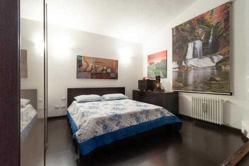 a bedroom with a bed and paintings on the wall at Villa Lorenz in Putignano