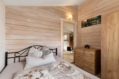 a bedroom with a bed and a wooden wall at Blockhütte in Fürstenwalde