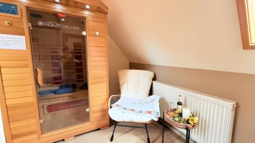 a white chair sitting next to a glass cabinet at Schwarzwaldhaus Zwink Ferienhaus in Enzklösterle