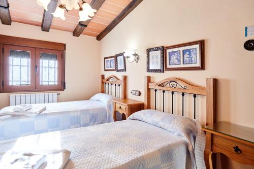 a bedroom with two beds and a wooden ceiling at La Acacia in Martos