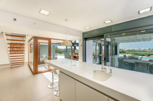 a kitchen with a counter and a large window at Villa Canutells Ref 27 in Mahón