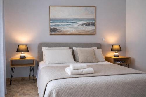 a bedroom with a bed with two lamps on both sides at Elysium Living in Gouvia