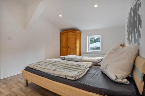 a bedroom with a large bed with a wooden headboard at Wohnung Obergeschoss in Funfseen