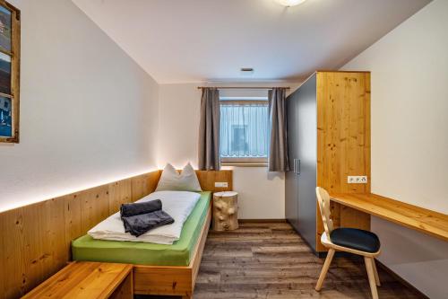 a small room with a bed and a chair at Krämerhof Apt Peitlerkofel in Rodengo