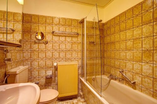 a bathroom with a toilet and a tub and a sink at Haus Zur Laterne in Willingen