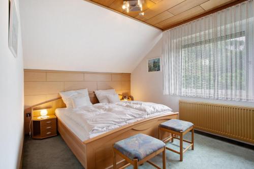 a bedroom with a bed and two chairs in it at Haus Zur Laterne in Willingen