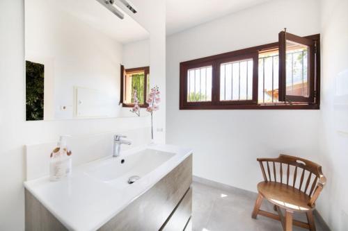 a bathroom with a sink and a wooden chair at Villa Rae in Sóller