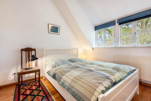 a bedroom with a bed and two windows at Landhaus im Garten in Hude