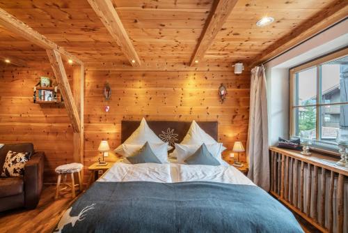 a bedroom with a large bed in a room with wooden walls at Chalet Bergliebe mit Zirbenholz in Inzell