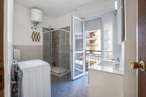 a bathroom with a sink and a glass door at Iris Apartment Lago Maggiore in Angera