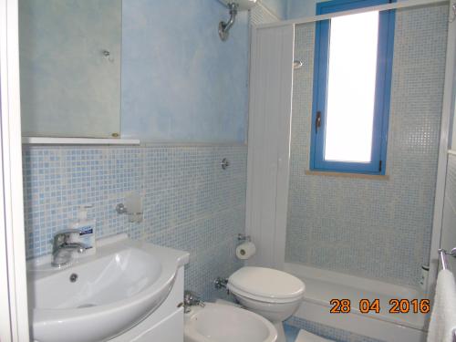 uma casa de banho com um lavatório branco e um WC. em Villa Sonia em Realmonte