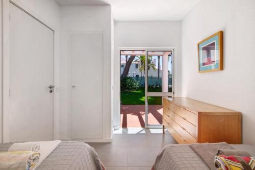 a bedroom with a bed and a dresser and a door at Villa Lynn - Quadradinhos in Almancil