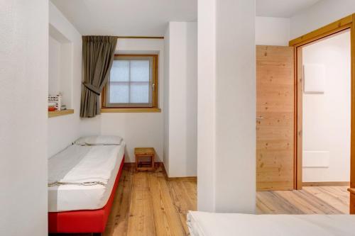 a small room with two beds and a window at Chalet Pieri - Appartamento Bedogn in Bormio