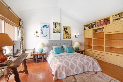 a bedroom with a large bed with blue pillows at T3 Duplex Albufeira in Olhos de Água