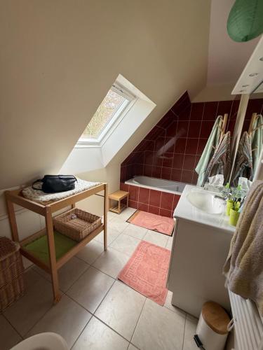 a attic bathroom with a sink and a tub at Les Buissons in Saint-Pierre-le-Vieux
