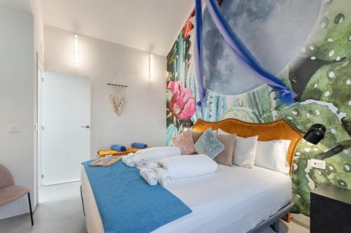 a bedroom with a bed with a painting on the wall at Apartamentos Puntagrande in Frontera