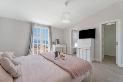 a white bedroom with a bed and a table with fruit on it at Casa el Jable in Guía de Isora