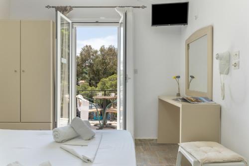 a bedroom with a bed and a sliding glass door at Ilias Voula Studios in Kalymnos