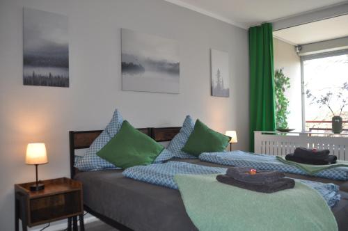 a bedroom with two beds with green and blue pillows at Backbordkajüte am Steinhuder Meer in Wunstorf