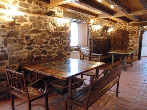 a room with stone walls and wooden tables and benches at El Mirador Del Pedroso in Barbadillo del Pez