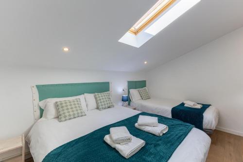 a bedroom with two beds with towels on them at El Arrebol Rural in El Espinar