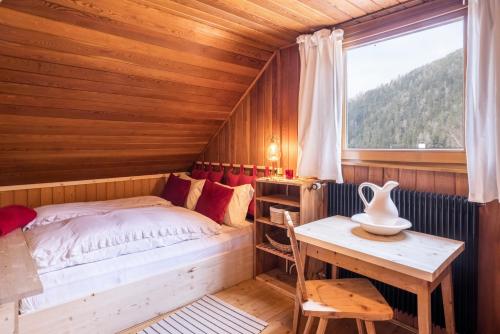 a bedroom with a bed and a table and a window at Ferienhaus Moarbach in Floronzo