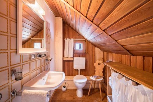 a bathroom with a white toilet and a sink at Ferienhaus Moarbach in Floronzo