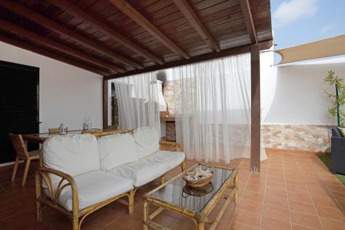 a living room with a white couch and a table at El Cortijo in La Oliva