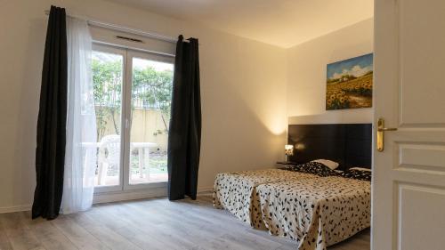 a bedroom with a bed and a sliding glass door at Virginia N104 - ST2 in Grasse