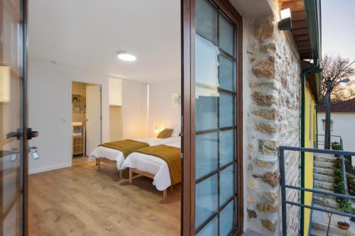 a bedroom with a bed and a glass door at Df Alojamentos e Suites in Coimbra