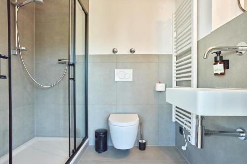 a bathroom with a shower and a toilet and a sink at Alte Seifensiederei - Lallaji in Bad Tölz